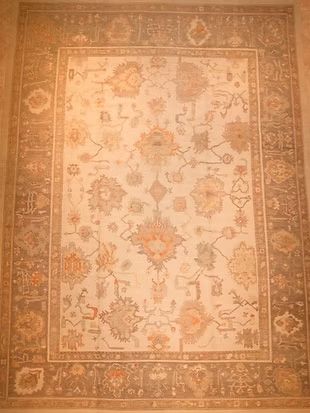 A rug with a floral pattern is sitting on a wall.