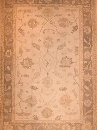 A rug with a floral pattern on it is hanging on a wall.