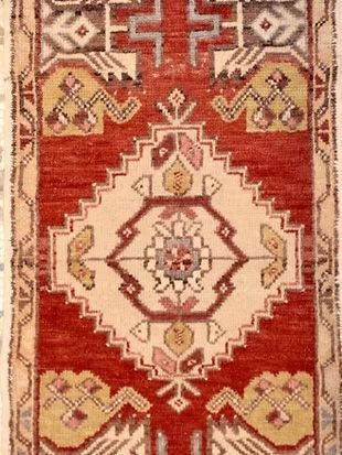 A red rug with a geometric pattern on it