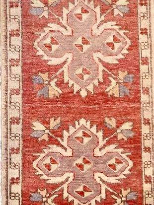 A red and white rug with a floral pattern on it.