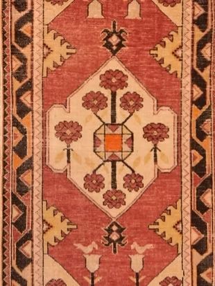 A rug with a geometric pattern and flowers on it