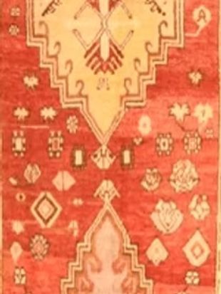 A red and yellow rug with a pattern on it