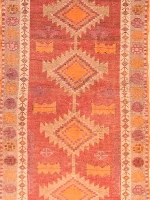 A red and orange rug with a geometric pattern on it.