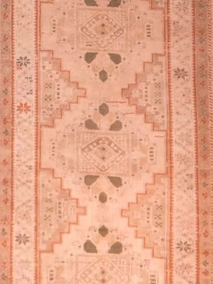 A close up of a pink rug with a pattern on it.