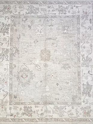 A close up of a white rug with a floral pattern on it.