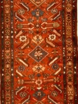 A red rug with a geometric pattern on it