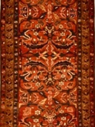 A red and brown rug with a floral pattern on it
