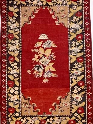 A red rug with flowers and leaves on it