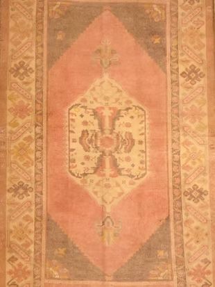A rug with a pattern on it is sitting on a wooden floor.