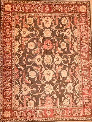 A rug with a floral pattern on it is hanging on a wall.