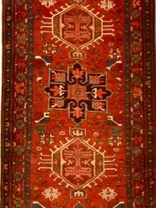 A red rug with a geometric pattern and the letter e on it
