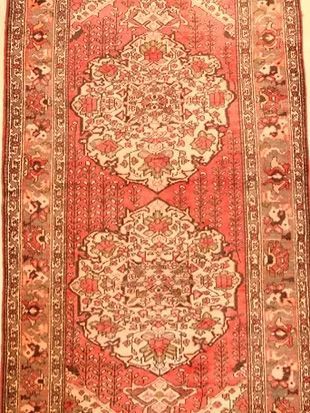 A red rug with a pattern on it is sitting on a table.
