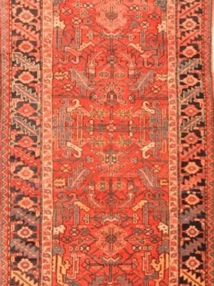 A red rug with a pattern on it is sitting on a table.