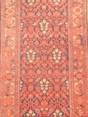 A close up of a red rug with a pattern on it.