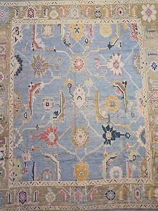 A blue rug with a pattern of flowers and keys on it.