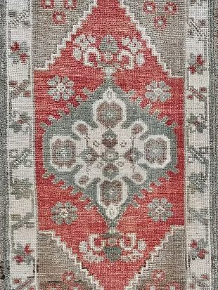 A close up of a red and gray rug with a pattern on it.