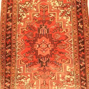 A red rug with a geometric pattern on it