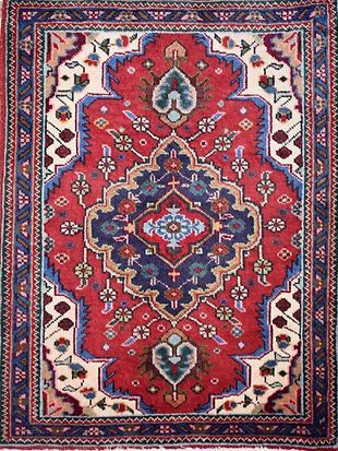 A red and blue rug with a floral pattern on it.