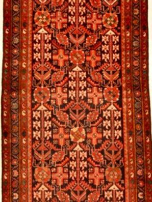 A red and black rug with a floral pattern on it.