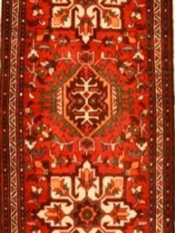 A red and brown rug with a geometric pattern on it