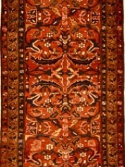 A red and brown rug with a floral pattern on it