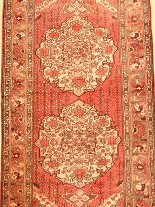 A red rug with a pattern on it is sitting on a table.