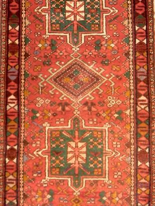 A red rug with a geometric pattern on it