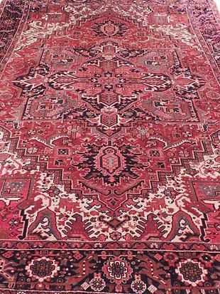 A close up of a red rug with a pattern on it.