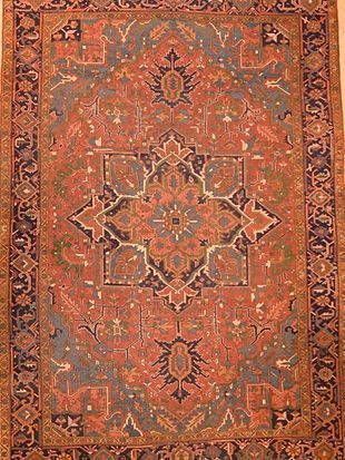 A rug with a pattern on it is hanging on a wall.