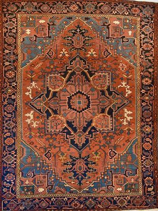 A rug with a pattern on it is hanging on a wall.