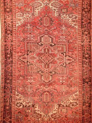 A close up of a red rug with a pattern on it.