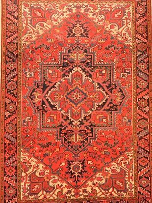 A red rug with a pattern on it is sitting on a table.
