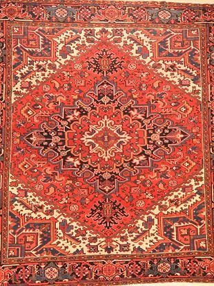 A close up of a red rug with a pattern on it.