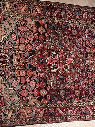 A rug with a floral pattern is sitting on a tiled floor.