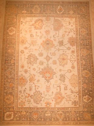A rug with a floral pattern is hanging on a wall