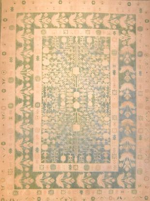 A rug with a floral pattern and a green border