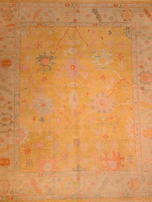 A close up of a yellow rug with a floral pattern on it.