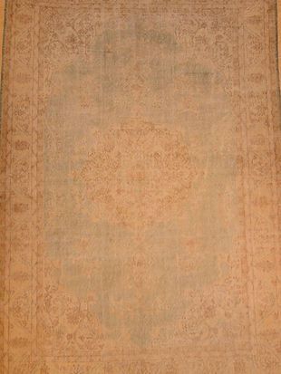 A close up of a brown rug on a wooden floor.