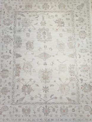 A white rug with a floral pattern on it is sitting on a table.