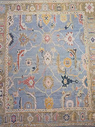 A close up of a blue rug with a floral pattern on it.