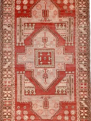 A red and white rug with a geometric pattern on it