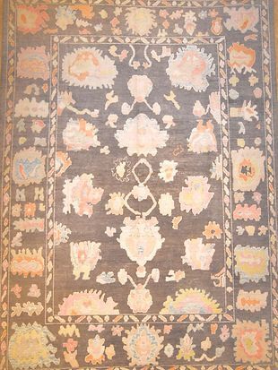 A rug with a floral pattern on it is hanging on a wall.