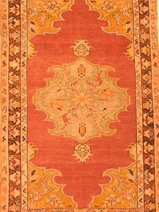 A red and yellow rug with a floral design on it