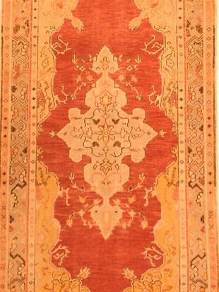 A red and yellow rug with a floral pattern on it