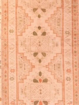 A close up of a pink rug with a pattern on it.