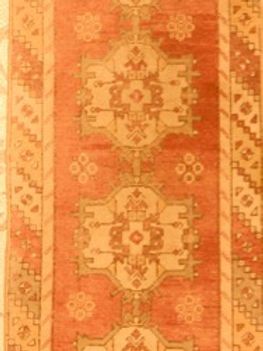 A red and tan rug with a pattern on it