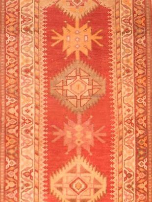 A red and yellow rug with a geometric pattern on it
