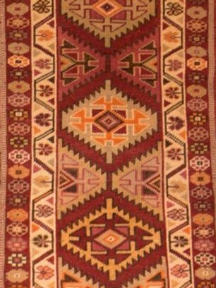A red rug with a geometric pattern on it