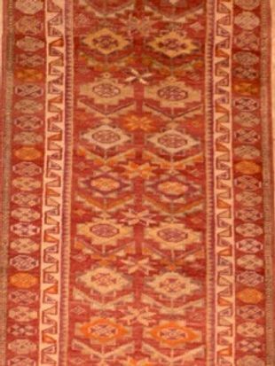 A red and yellow rug with a pattern on it