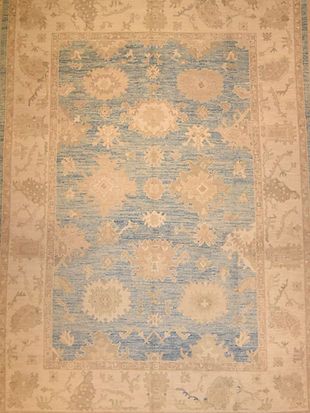 A close up of a rug with blue and white flowers on it.
